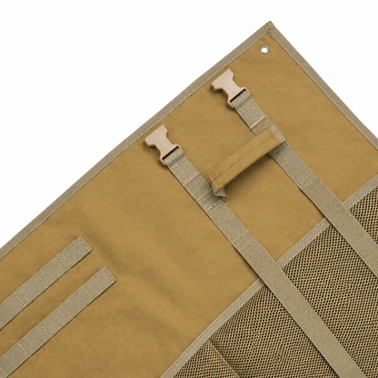 Close-up view of tan shooting mat interior showing fixed webbing, quick release buckles, a portable handle, and MOLLE attachment system for gear.